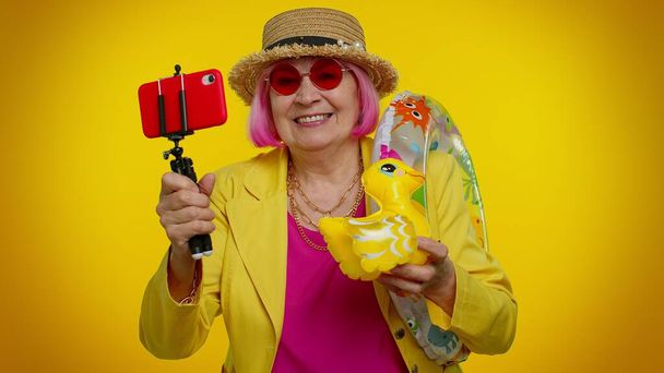 Reife Großmutter Reisender Blogger mit Sonnenbrille, Selfie auf dem Handy, Videotelefonie online - Foto, Bild