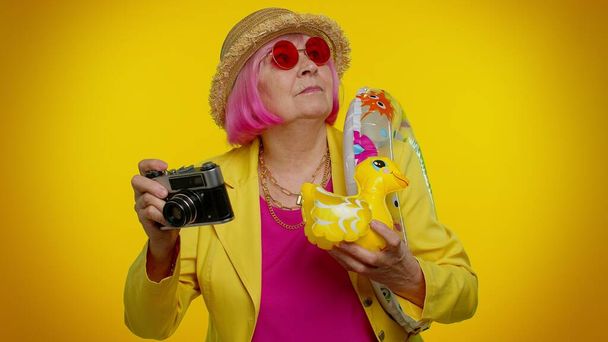 Старшая женщина бабушка турист фотограф делает фотографии на ретро-камеру, путешествия, каникулы - Фото, изображение