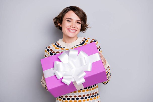 Portrait of attractive cheerful girl holding in hands handling delivering you gift isolated over grey pastel color background - Zdjęcie, obraz