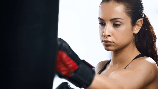 entrenamiento de deportista enfocado con saco de boxeo en gimnasio  - Foto, Imagen