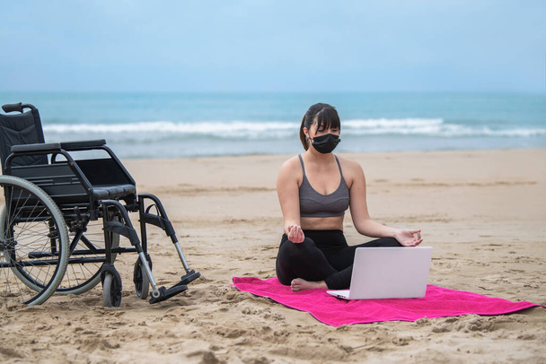 fiatal nő csinál meditáció előtt a laptop: felépülni az utóhatásai covid-19 - Fotó, kép