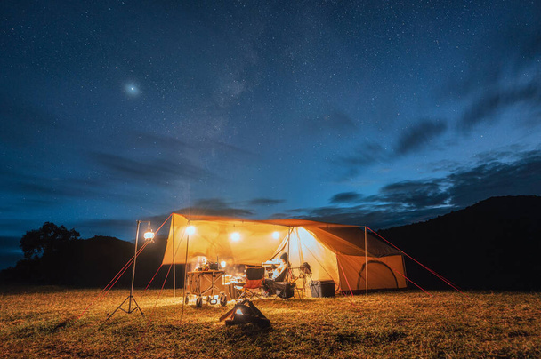 Touristen im gelben Zelt campieren auf einem Hügel mit Milchstraße am Nachthimmel im Nationalpark - Foto, Bild