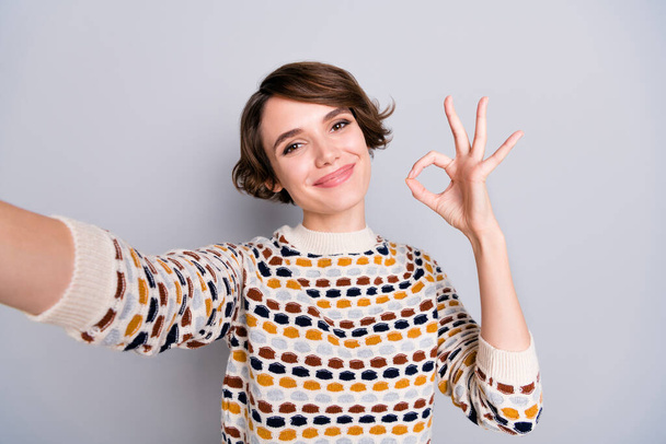 Self-portrait of lovely cheerful girl showing ok-sign deal ad cool isolated over grey pastel color background - Фото, изображение