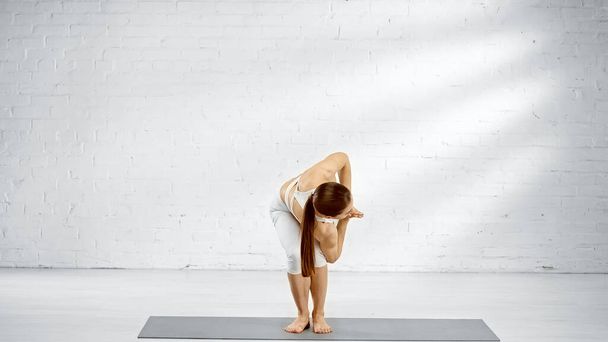 Bruneta žena stojící v křesle twist jóga póza - Fotografie, Obrázek