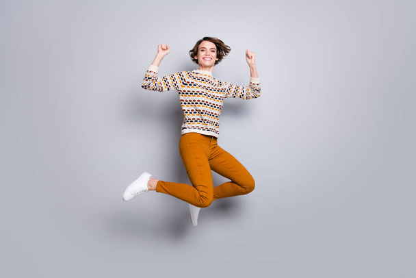 Full length body size view of lovely lucky cheerful girl jumping rejoicing having fun isolated over grey pastel color background - Foto, Imagen