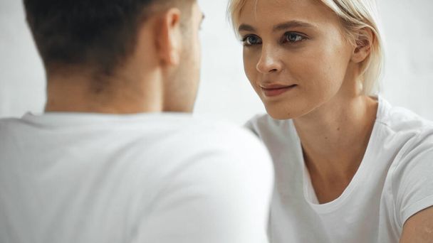 blonde woman looking at boyfriend on blurred foreground  - Fotó, kép