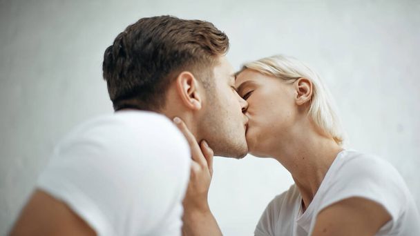 young blonde woman kissing with boyfriend  - Foto, afbeelding
