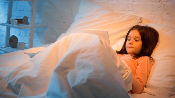 Child using digital tablet in bed  - Zdjęcie, obraz