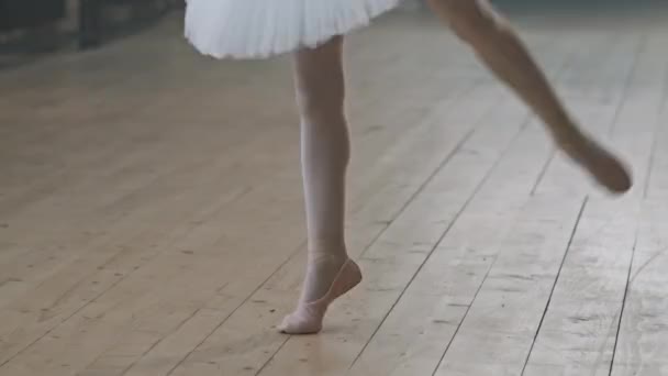 Tirador de sección baja de pequeñas bailarinas piernas en zapatos puntiagudos bailando ballet en piso de madera en estudio de baile - Imágenes, Vídeo