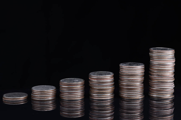 Heaps of coins standing in ascending order on black background - Фото, изображение