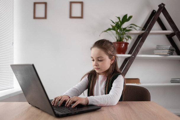 İnternet bağımlısı liseli kız bir dizüstü bilgisayarın başına oturmuş mesaj yazıyor ya da internet üzerinden bir ağ oyunu oynuyor. Modern zeki öğrencilerin bağımlılık problemi. Eğitim dersi video iletişimi. - Fotoğraf, Görsel