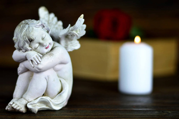 Άγγελος, λευκό κερί και κόκκινο τριαντάφυλλο σε ξύλινο φόντο - Φωτογραφία, εικόνα