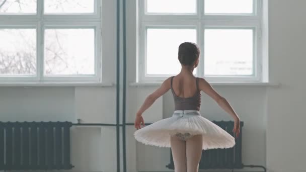 Mediana toma de talentosa bailarina de 9 años en tutú tocando el ballet de baile de cisne en el estudio de coreografía - Imágenes, Vídeo