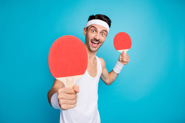 Photo of young excited sportive man happy smile play ping-pong hold racquet isolated over blue color background - Photo, Image