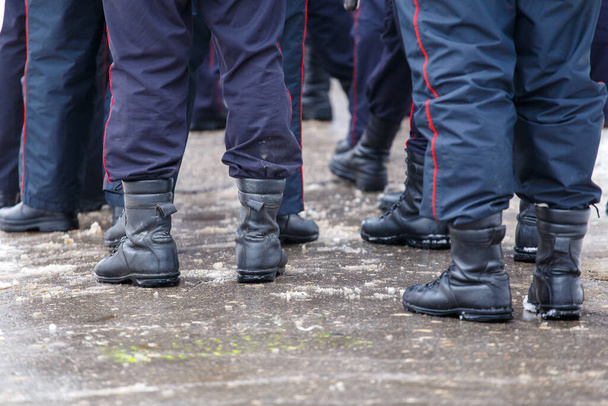 Beine russischer Polizisten in schwarzen Stiefeletten - Nahaufnahme mit selektivem Fokus - Foto, Bild