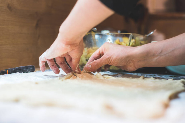 Close up of woman rolling traditional dough in the kitchen - Foto, imagen