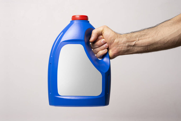 A male hand holding a blue kitchen detergent bottle - Fotoğraf, Görsel