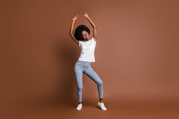 Full length body size photo of dancing woman wearing casual outfit isolated on brown color background - Photo, Image