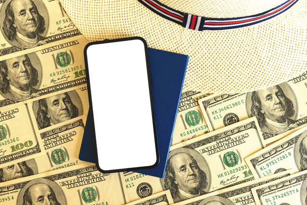 Дорогие путешествия макет концепт фото, смартфон с чистым белым экраном на фоне денег, долларов США - Фото, изображение