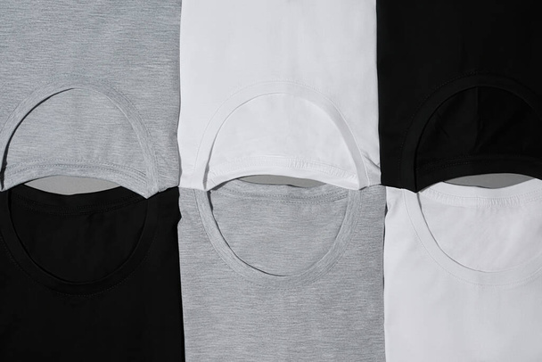 Top view of folded monochrome cotton t shirts of black, gray and white colors - Foto, Imagem