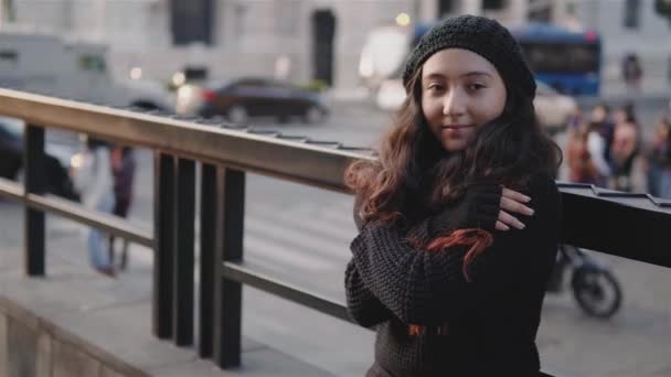 Teini katsomassa ihmisiä kaupungissa hän pukeutuu talvivaatteita - Materiaali, video