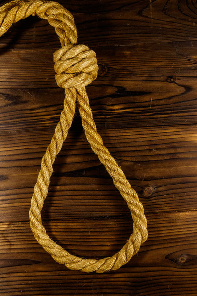 Deadly loop of rope on a wooden background. Concept of death penalty or suicide - Photo, Image