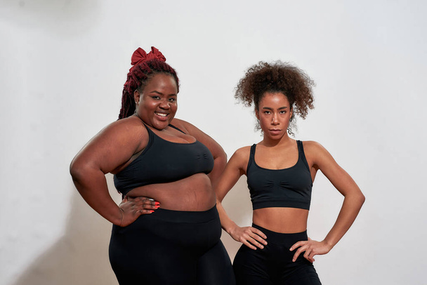 Black women with different skin colour standing with hands on hips - 写真・画像