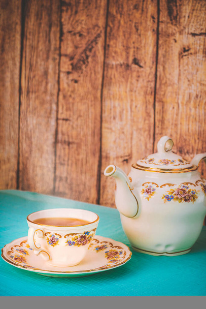Widok na filiżankę herbaty i porcelanowy dzbanek na stole o zachodzie słońca - Zdjęcie, obraz