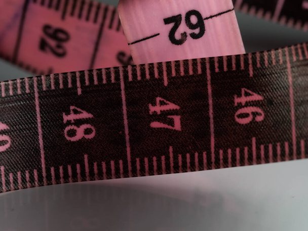 Close up tailor measuring tape on white table background. White measuring tape shallow depth of field. Macro. - Photo, Image