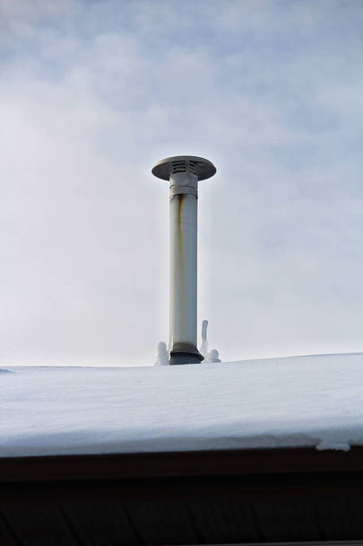 Frozen icicles beside a chimney stack in winter - Photo, Image