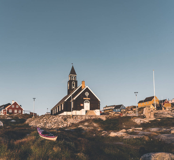 Old wooden Zions Church in arctic city of Ilulissat, with midnight sun light and blue sky in North Greenland - Foto, Bild