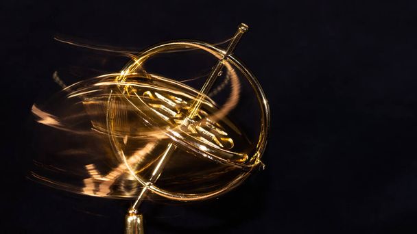 Złoty żyroskop wirujący dziko na podstawie - Zdjęcie, obraz