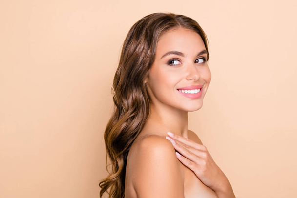 Photo of young charming lovely happy woman look copyspace apply body cream isolated on beige color background - Fotografie, Obrázek
