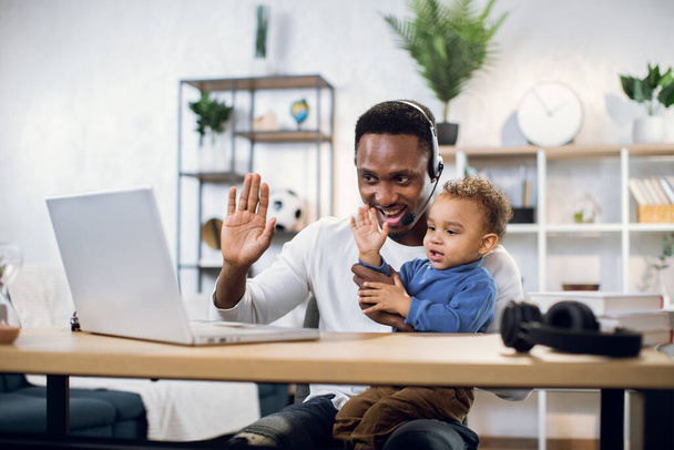 Afro businessman with his son on hands having video chat - Fotoğraf, Görsel