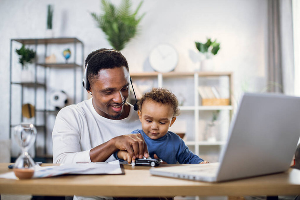 Afričtí podnikatelé pracují na notebooku a nosí dítě syn - Fotografie, Obrázek