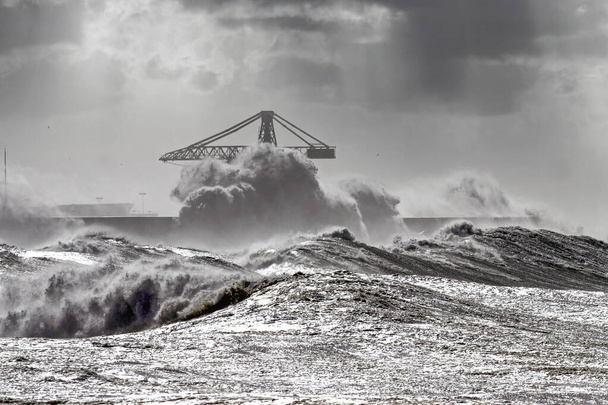 Μεγάλα κύματα κατά τη διάρκεια καταιγίδας στις πορτογαλικές ακτές. Βόρεια πλευρά του λιμανιού Leixoes, βόρεια της Πορτογαλίας. Ενισχυμένος ουρανός. - Φωτογραφία, εικόνα