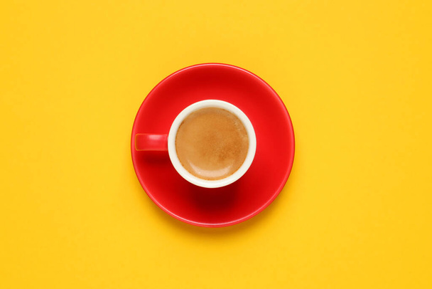 Aromatic coffee in red cup on yellow background, top view - Foto, Bild