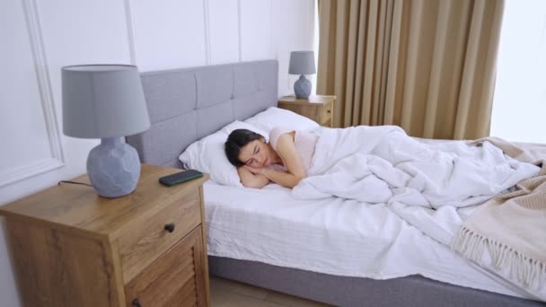 Jonge vrouw slaapt in comfortabel bed - Video