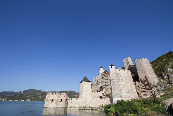 Twierdza Golubac (Golubacka trvdjava lub Goluback Grad) widziana z rzeki Dunav. Zamek Golubac był średniowiecznym ufortyfikowanym miastem nad Dunajem, 4 km w dół rzeki od obecnego miasta.. - Zdjęcie, obraz