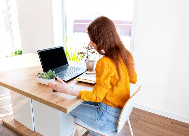 Defocus. Young woman is education online by using computer. Female freelancer browsing in laptop. Concept of information overload. Technology and people. Comfort Zone at home. Networking business. - 写真・画像