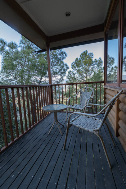 Ein malerischer Blick vom Balkon mit Bäumen ringsum und Stühlen zum Entspannen - Foto, Bild