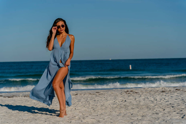 Un hermoso modelo de bikini de raza mixta disfruta del clima al aire libre en la playa - Foto, Imagen