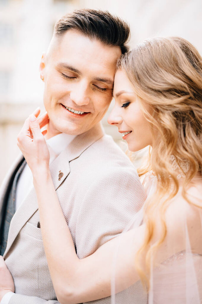 Nevěsta drží dlaň na bradě usměvavého ženicha - Fotografie, Obrázek