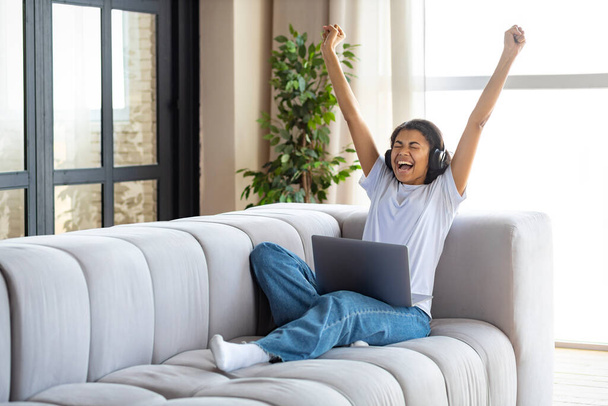 Overjoyed young African American woman win online lottery or got great news by email on laptop  - Photo, Image