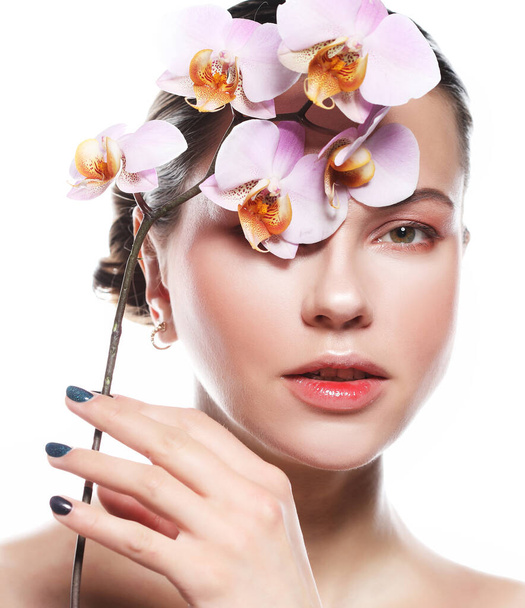 beautiful young woman with bright makeup in pink tones holds an orchid, shooting on a white background - Foto, Bild