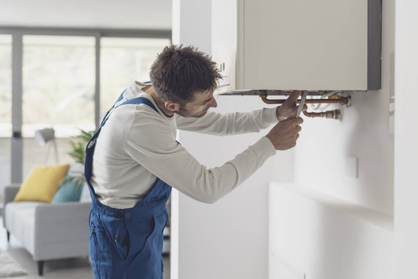 Professional plumber checking a boiler and pipes, boiler service concept - Φωτογραφία, εικόνα