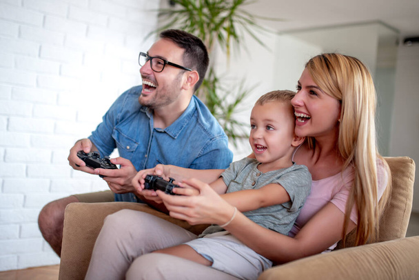 幸せな家族は彼らのリビングルームでビデオゲームをプレイ. - 写真・画像