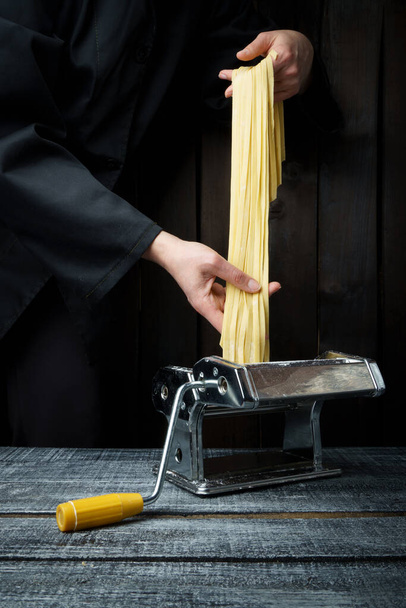 pasta in hands on a black background. homemade pasta. banner - 写真・画像