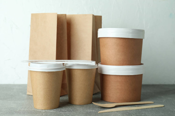 Доставка контейнерів для вилучення їжі на сірому текстурованому столі
 - Фото, зображення