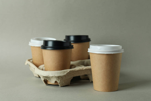 Cup holder with paper cups on light gray background - Foto, Imagen